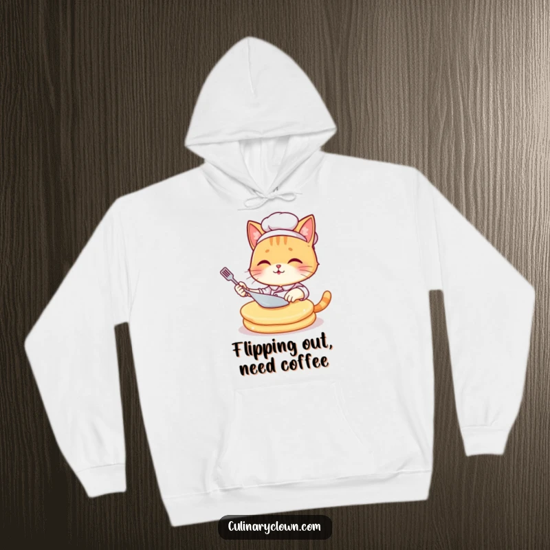 Funny kawaii cat chef looking flustered while attempting to flip a massive pancake, featured on a cozy hoodie.