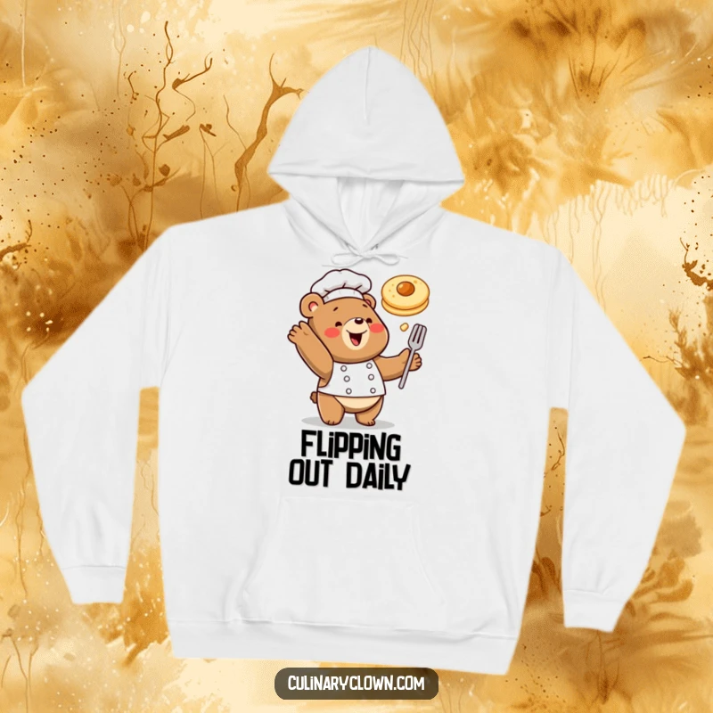 Funny hoodie showing a happy bear chef playfully tossing a pancake, perfect for cozy breakfast moments.