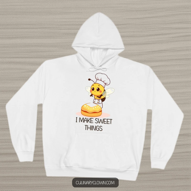 Funny bee chef sprinkling sugar onto a pastry, a cozy and humorous design on a comfortable hoodie.